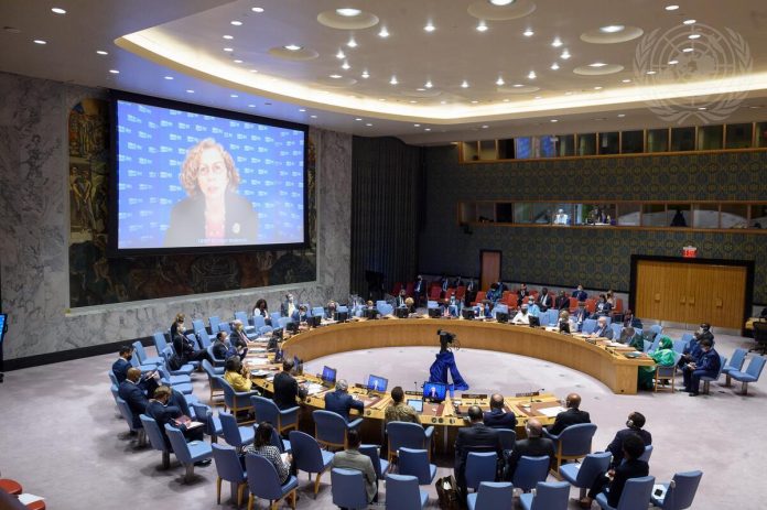 A wide view of the Security Council as Inger Andersen (on screen), Executive Director of the United Nations Environment Programme (UNEP), briefs the Council meeting on Peace and security in Africa. Foto: Loey Felipe/UN Photo consenso